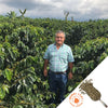 Farmer standing in the middle of their coffee field.